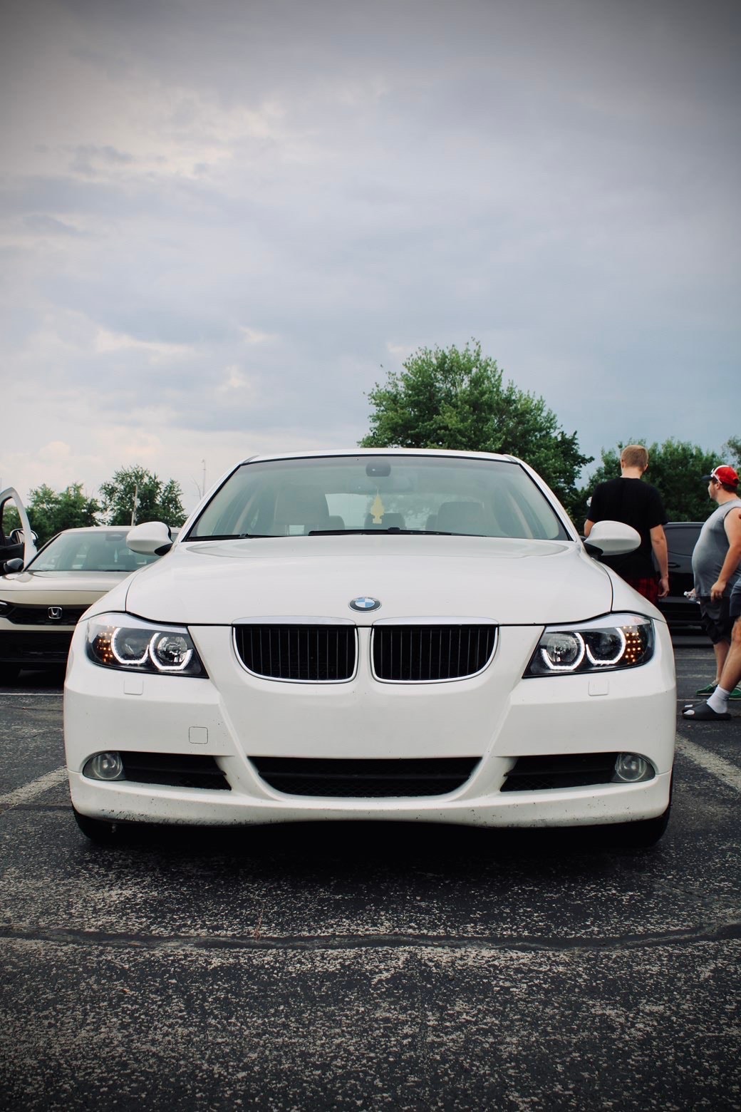 White compact car hood open in parking lot